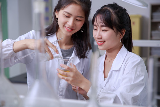 微笑的两名女学生在做实验