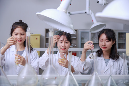 在实验室里做实验的三名学生