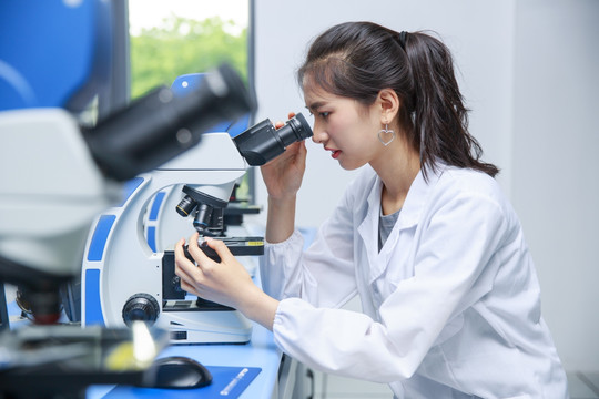 在用显微镜观察生物标本的女学生