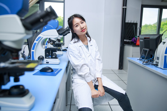 坐在实验室里微笑着的女学生