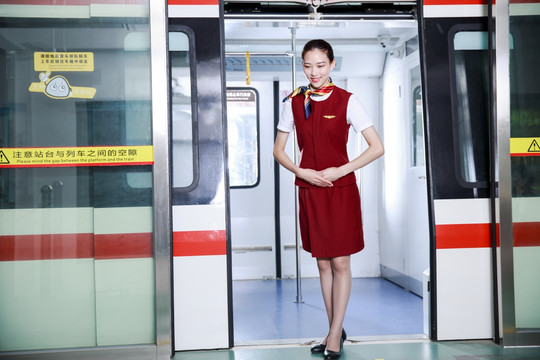 站在地铁门口优雅微笑的女乘务员