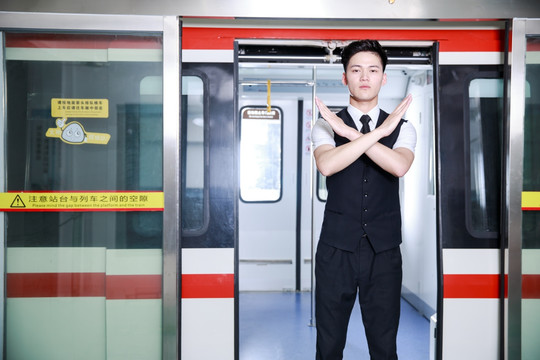 双臂打叉拒绝进入地铁的男乘务员