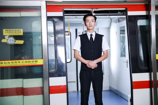 穿着制服的男乘务员站在地铁门口