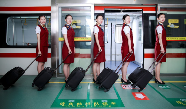 微笑着拉着行李箱的女乘务员们
