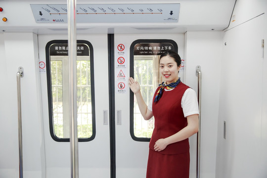 指着地铁门上禁止标志的女乘务员