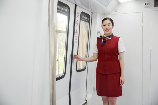 微笑的女乘务员站在地铁里