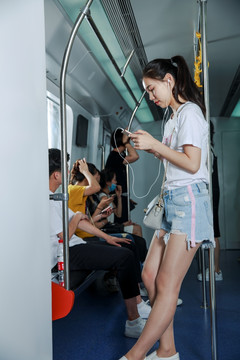 在地铁里使用手机的女乘客