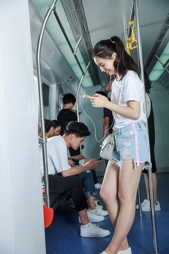 开心的女乘客在地铁里用手机