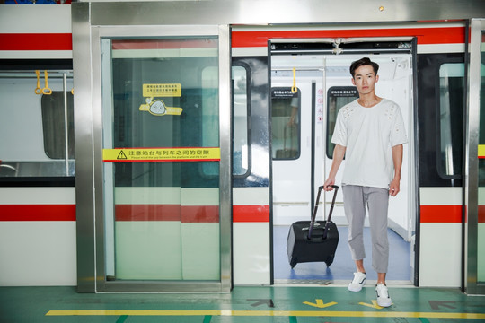 拉着行李箱走出地铁的男人