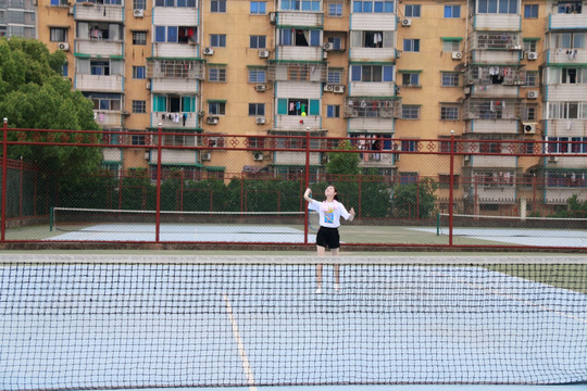 在球场上打网球的女大学生