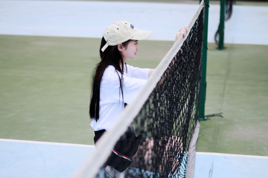 站在网球场上的女大学生
