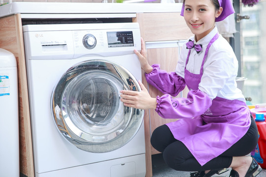 微笑着使用洗衣机的家政女人