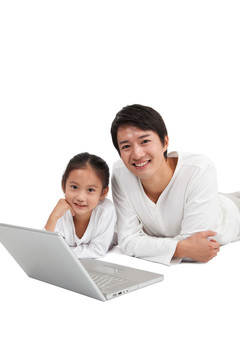 棚拍年轻父亲和小女孩使用笔记本电脑