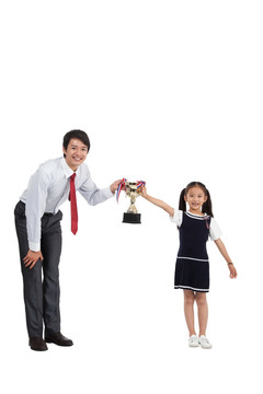 棚拍商务装年轻父亲 穿裙子的小女孩拿奖杯