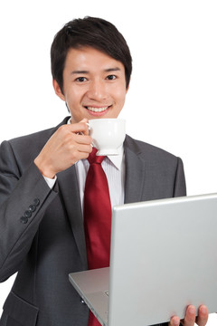 棚拍商务装年轻男人喝咖啡使用笔记本电脑