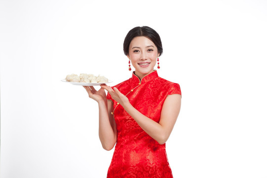 棚拍身穿中国传统服装的年轻女人端饺子