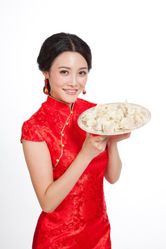 棚拍身穿中国传统服装的年轻女人端饺子