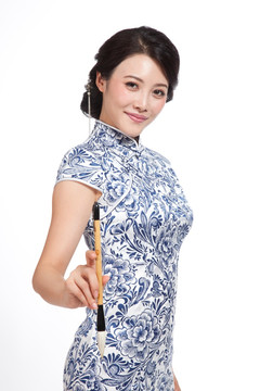 棚拍身穿中国传统服装的年轻女人和毛笔