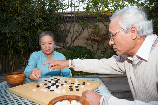 老夫妻在庭院里下棋