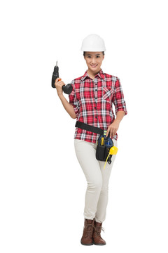 年轻的女建筑工人拿着电钻