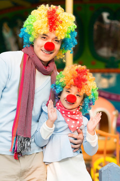 快乐的父女扮小丑在游乐园玩