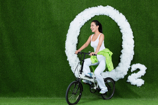 草地创意年轻女性骑自行车