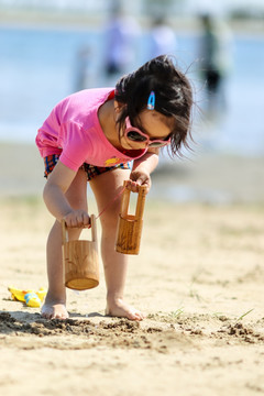站在沙滩上玩耍的女孩