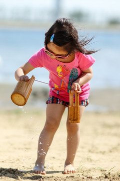 站在沙滩上玩耍的女孩
