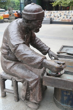 铜雕卖糖画的老人