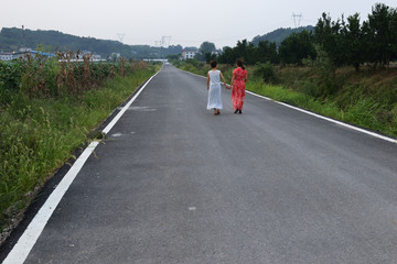 美女走在乡间小道上