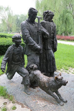 铜雕带狗赶场的男人和孩子