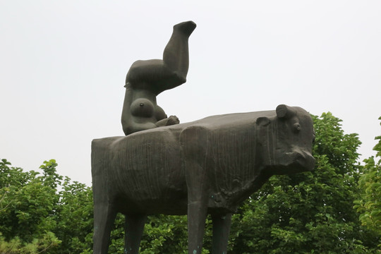 铜雕牛背上倒立的女人