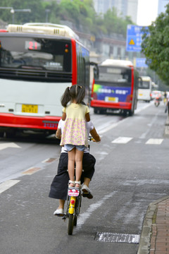 乘妈妈自行车的小女孩