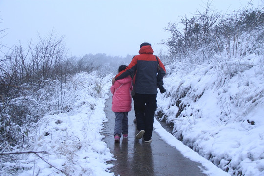 雪景中爸爸陪女儿散步