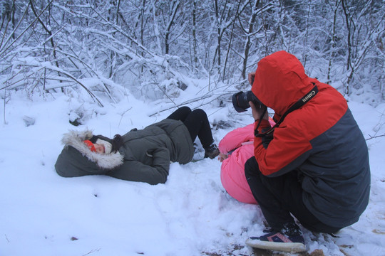 不怕冷躺在雪中拍照