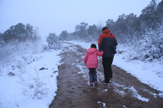 雪景中爸爸陪女儿散步
