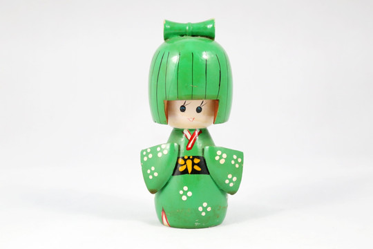 木雕穿绿色和服的娃娃