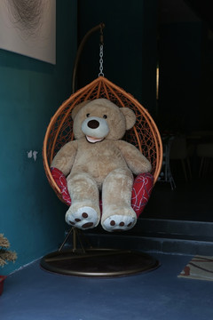 棕色色小熊坐在吊篮