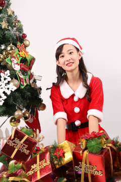戴着圣诞帽的女学生坐在圣诞树旁