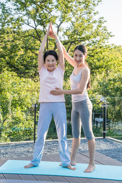 一个年轻女人在指导一个老年人锻炼身体