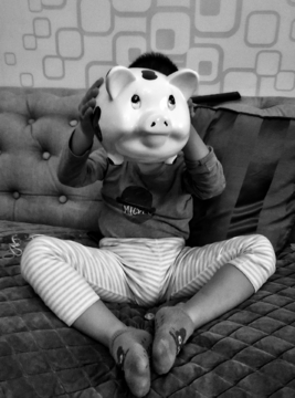 孩子手捧小猪存钱罐