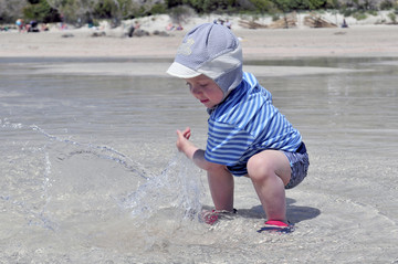 埃拉福尼西海滩水中玩耍的小男孩