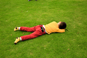 在草地上睡觉的小男孩