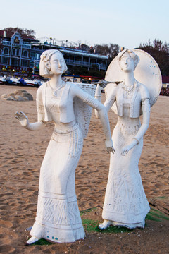 雕塑背篓背伞的少数民族男女
