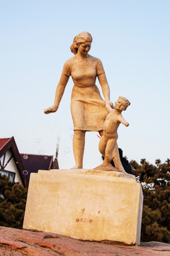 雕塑年轻女人牵着奔跑儿童