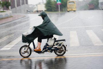 雨中骑电动车的妇女
