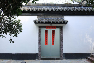 灰瓦白墙中式古典院门红对联