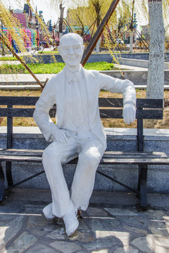 坐在椅子上休息的老年男人雕像