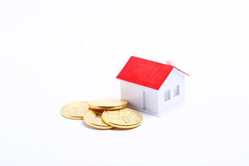 白背景上的硬币和房子模型