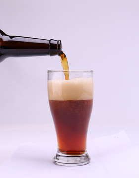 酒瓶倒啤酒黑啤啤酒杯有啤酒泡沫
